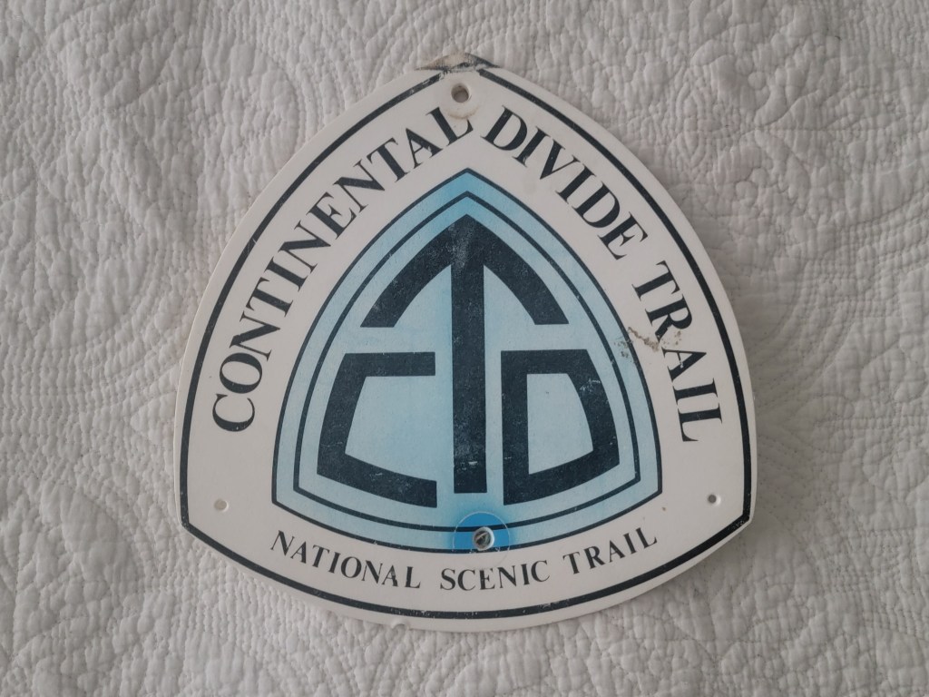 Sign for the Continental Divide Trail featuring the letters 'CDT' and labeled as a National Scenic Trail.
Plastic