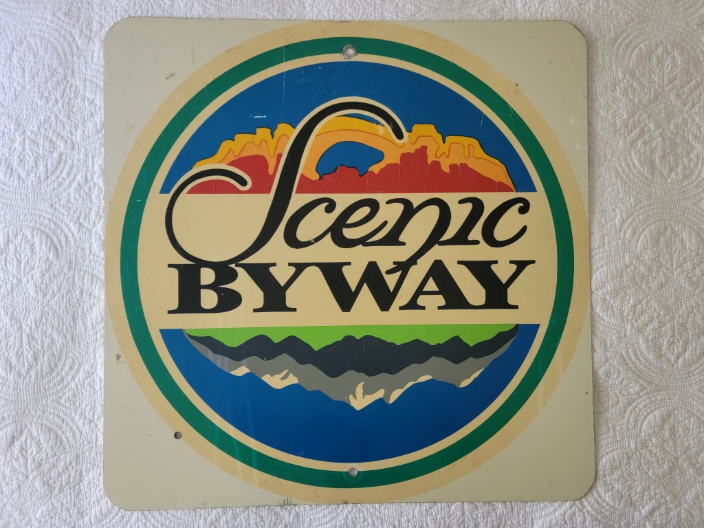 Vintage sign displaying 'Scenic Byway' in colorful letters with a landscape design.
Utah Scenic Byway Sign Arches Monument and Mountains