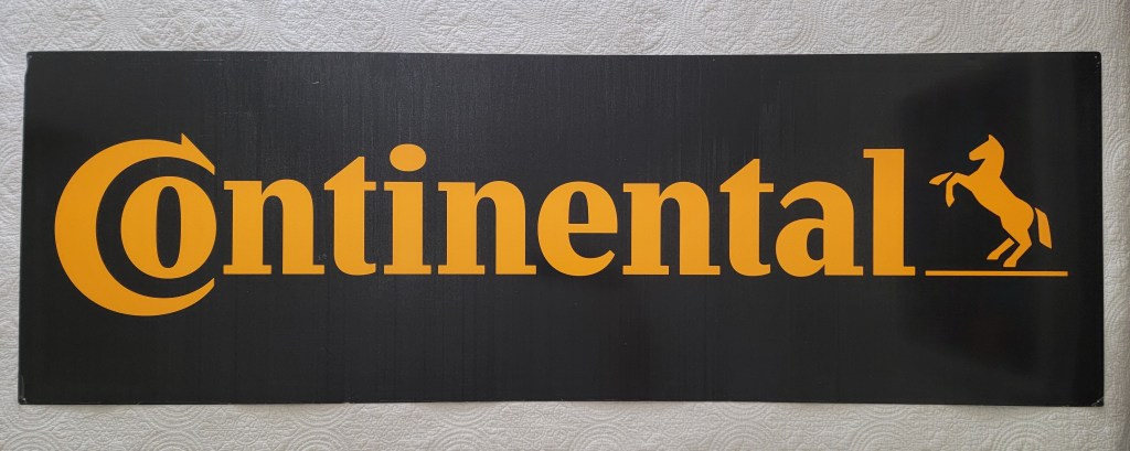 Black sign with yellow text reading 'Continental' and an illustration of a horse.