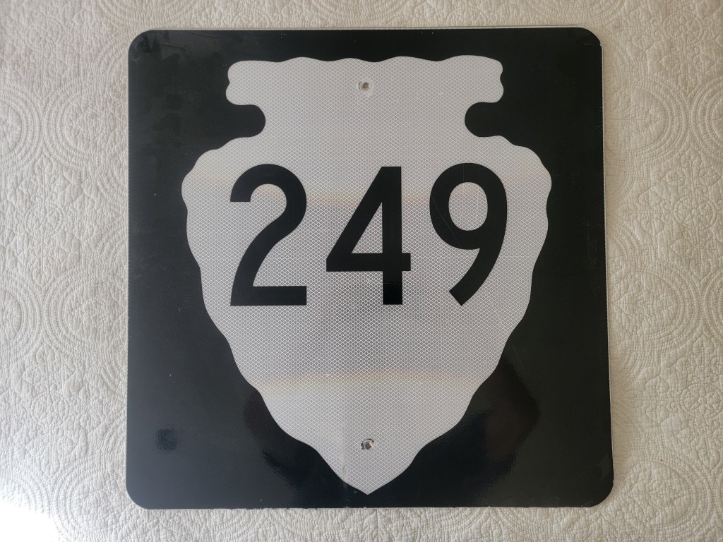 A black and white road sign displaying the number 249.
Montana arrowhead street route sign 249