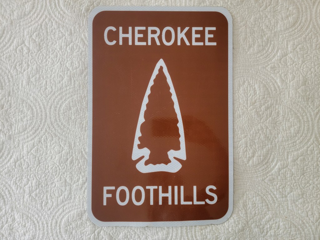 Brown sign with white text reading 'CHEROKEE FOOTHILLS' and an image of an arrowhead
South Carolina Indian Arrowhead street sign