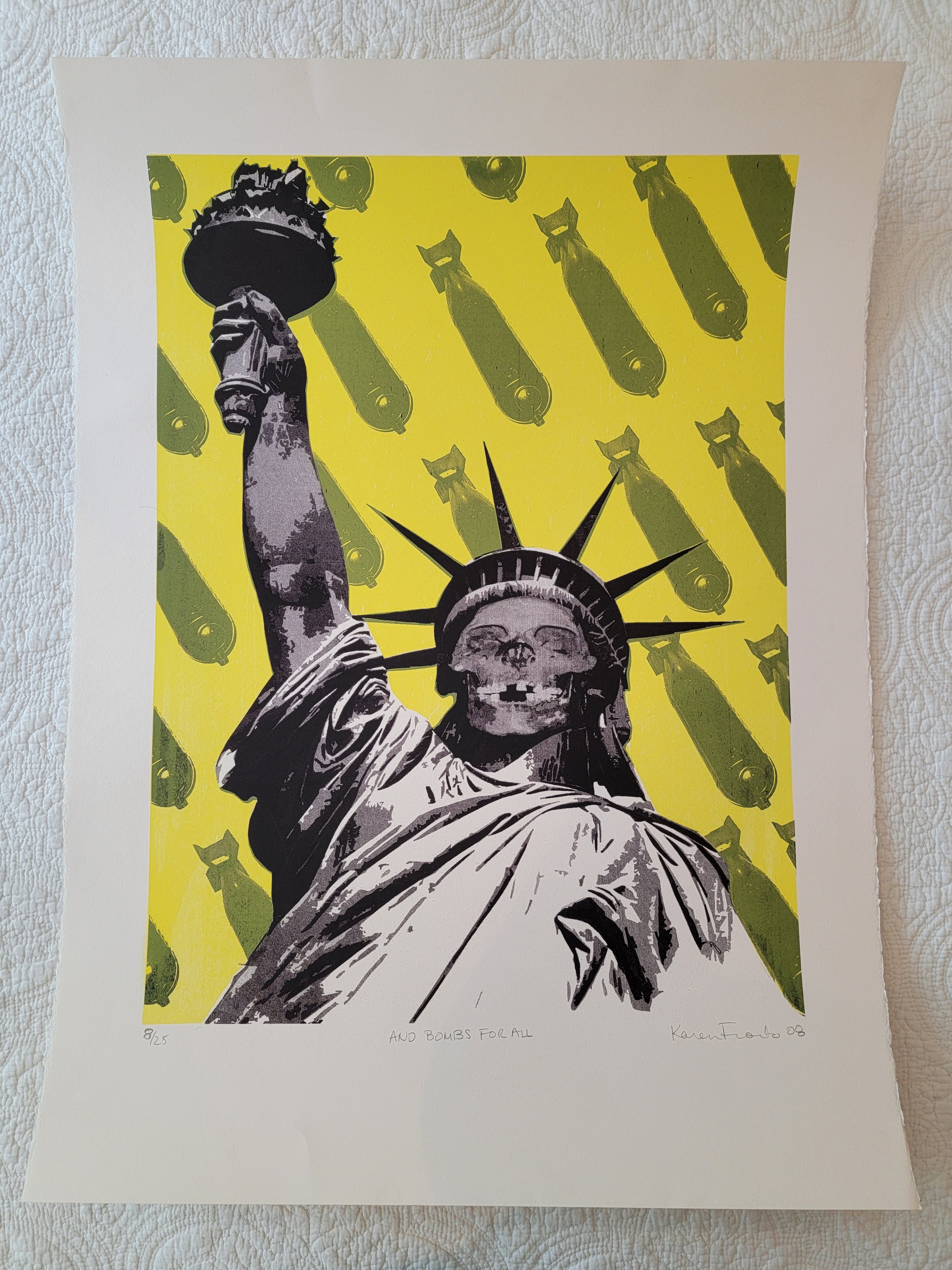 A stylized artwork of the Statue of Liberty with a skull face, holding a torch above, set against a bright yellow background featuring repeated bomb motifs.
Karen Fiorito And Bombs For All Signed Serigraph 8/25 2008